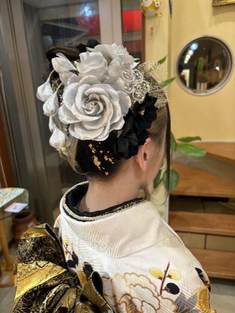 高めアップの成人式アップヘア。水引と花飾りを使い、上品で華やかな後ろ姿の和装ヘアスタイル。