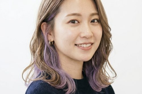 インナーカラーを入れた女性のパーマスタイル。柔らかいカールとチラ見えするカラーが特徴。