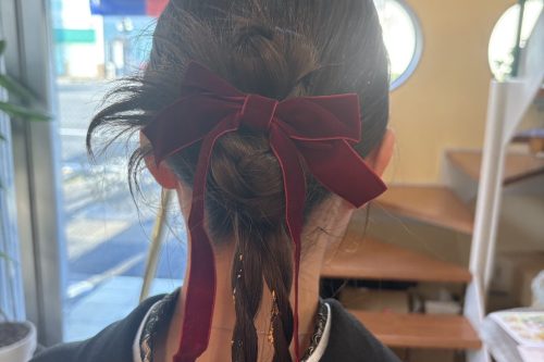 卒業式の袴に合わせた低めお団子と編みおろしアレンジ。赤いリボンがアクセントの上品で大人可愛い後ろ姿ヘアセット